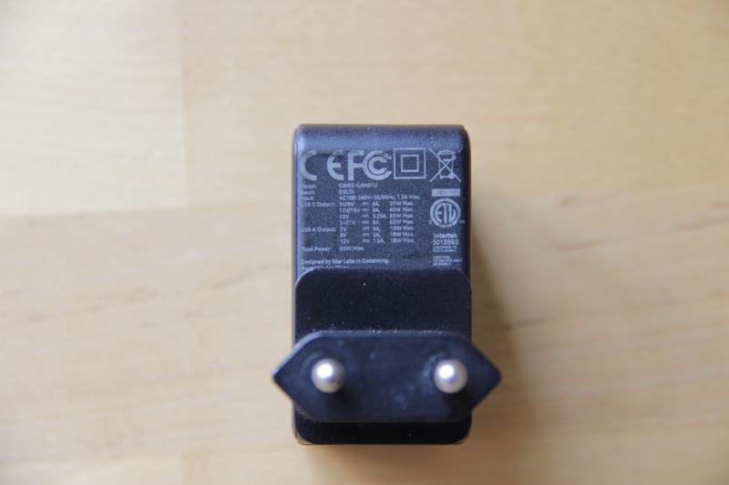 Photographie d'un chargeur USB se branchant sur le secteur. Les inscriptions indiquent que pour l'USB-C il supporte jusqu'à 65 W, que pour l'USB-A il supporte jusqu'à 18 W et que le total USB C + A ne peut pas dépasser 65 W.